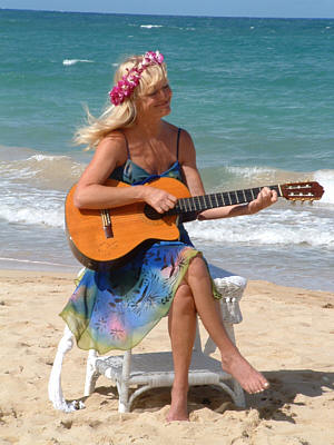 Kimmarie Butler playing the guitar on th ebeach at a wedding